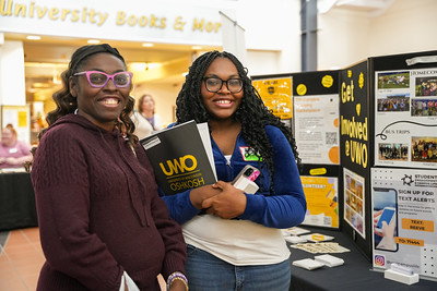 Two female students at a "How to get Involved" table during Titan Takeoff