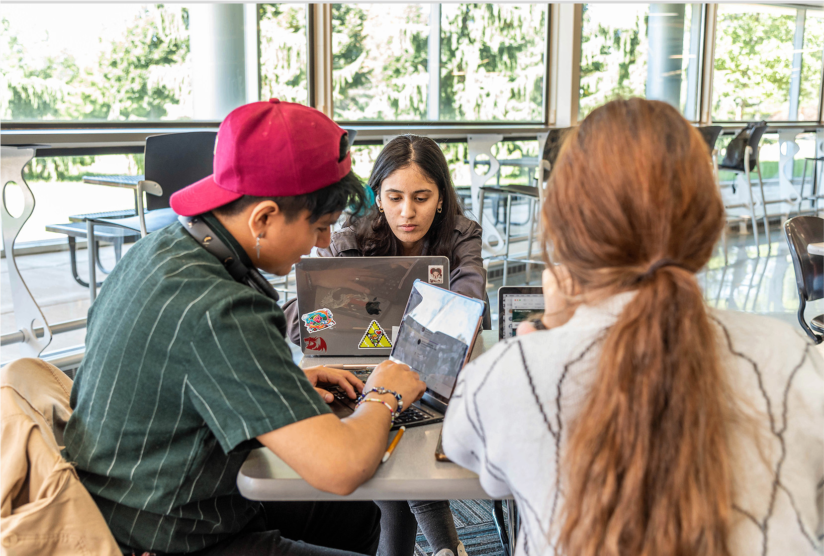 Students sitting at a table with laptops