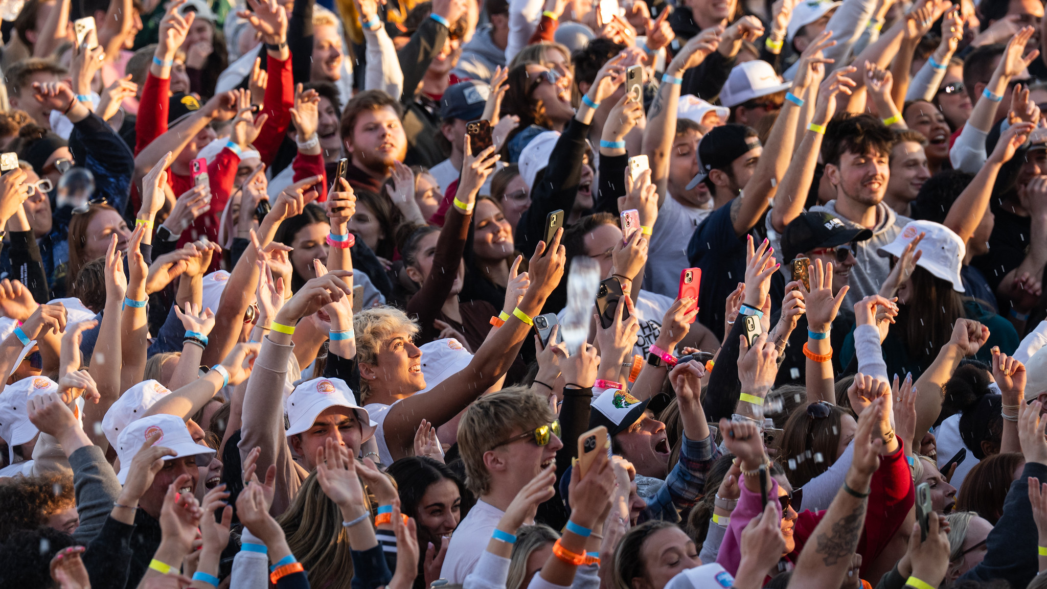 Students at UW-Oshkosh ByeGosh Fest with their hands in the air singing