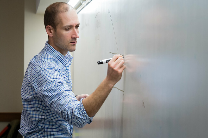 Student at UW-Oshkosh planning on a whiteboard